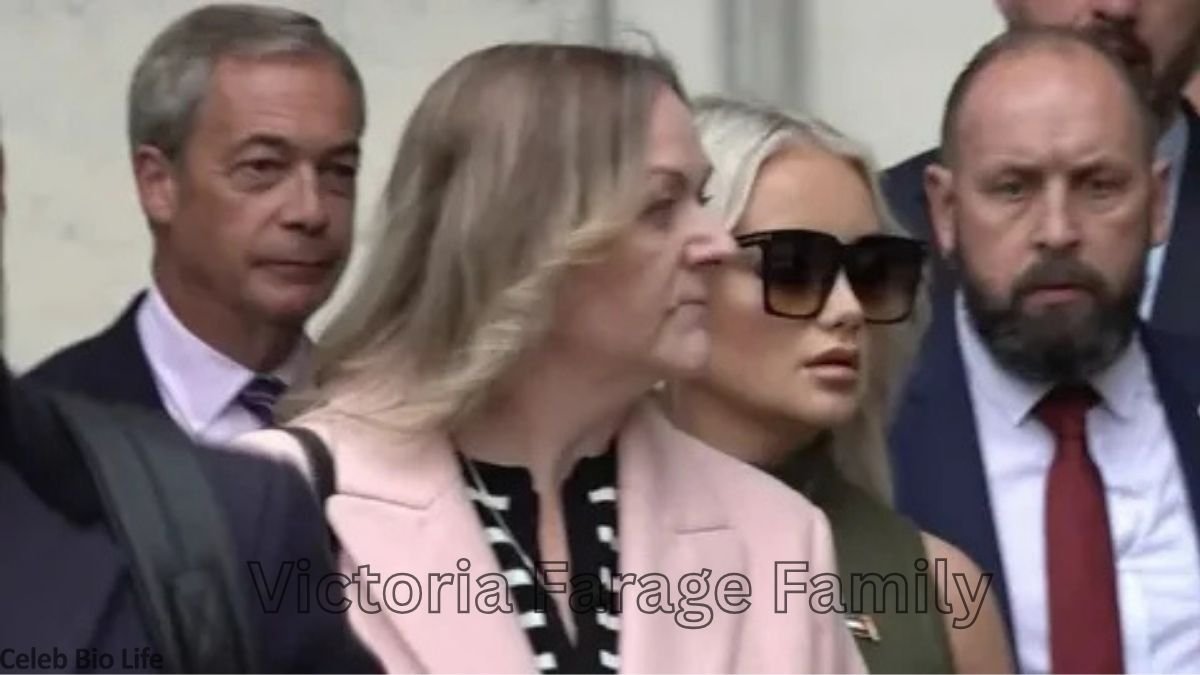 Blonde woman in pink coat surrounded by people