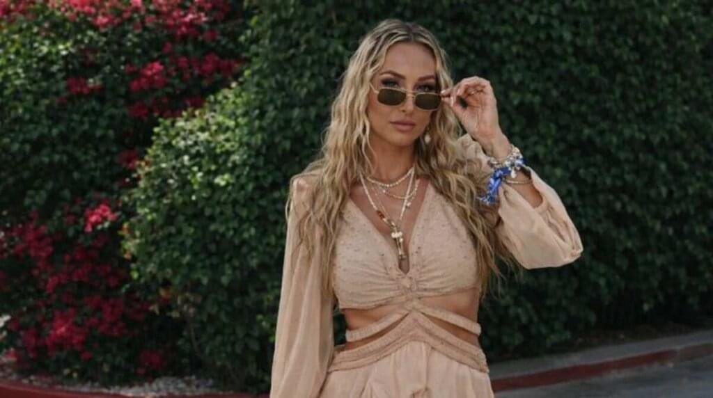 Amanda Ivanelli wearing a beige stylish summer outfit with sunglasses, outdoor fashion look with greenery background